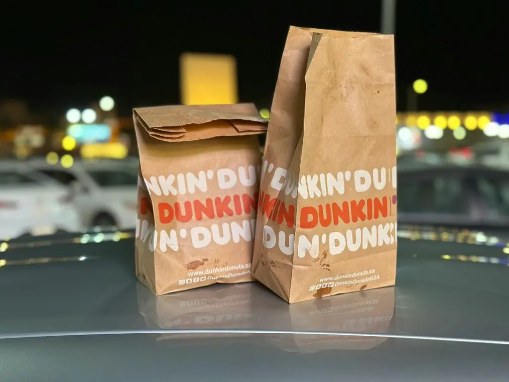 Dunkin' Donuts Bags on Car Hood at Night