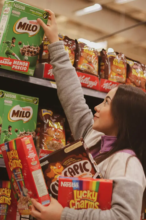 A woman getting cereal boxes from the shelf, one of many popular Nestle products